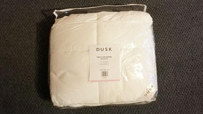 Dusk Feels Like Down edredón en una bolsa de plástico, sobre una alfombra