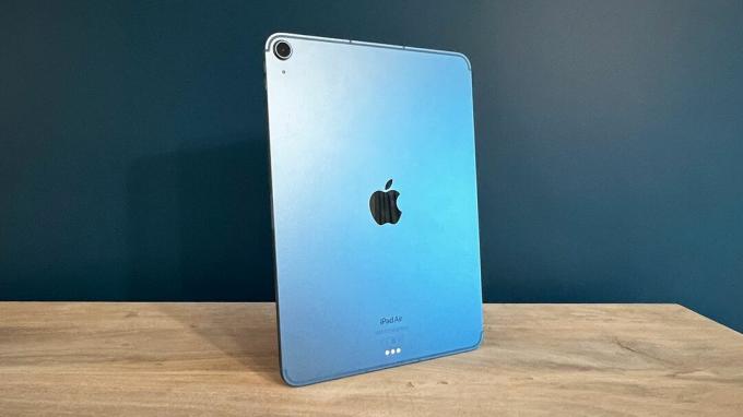 iPad Air 2022 ant medinio stalo mėlynu fonu
